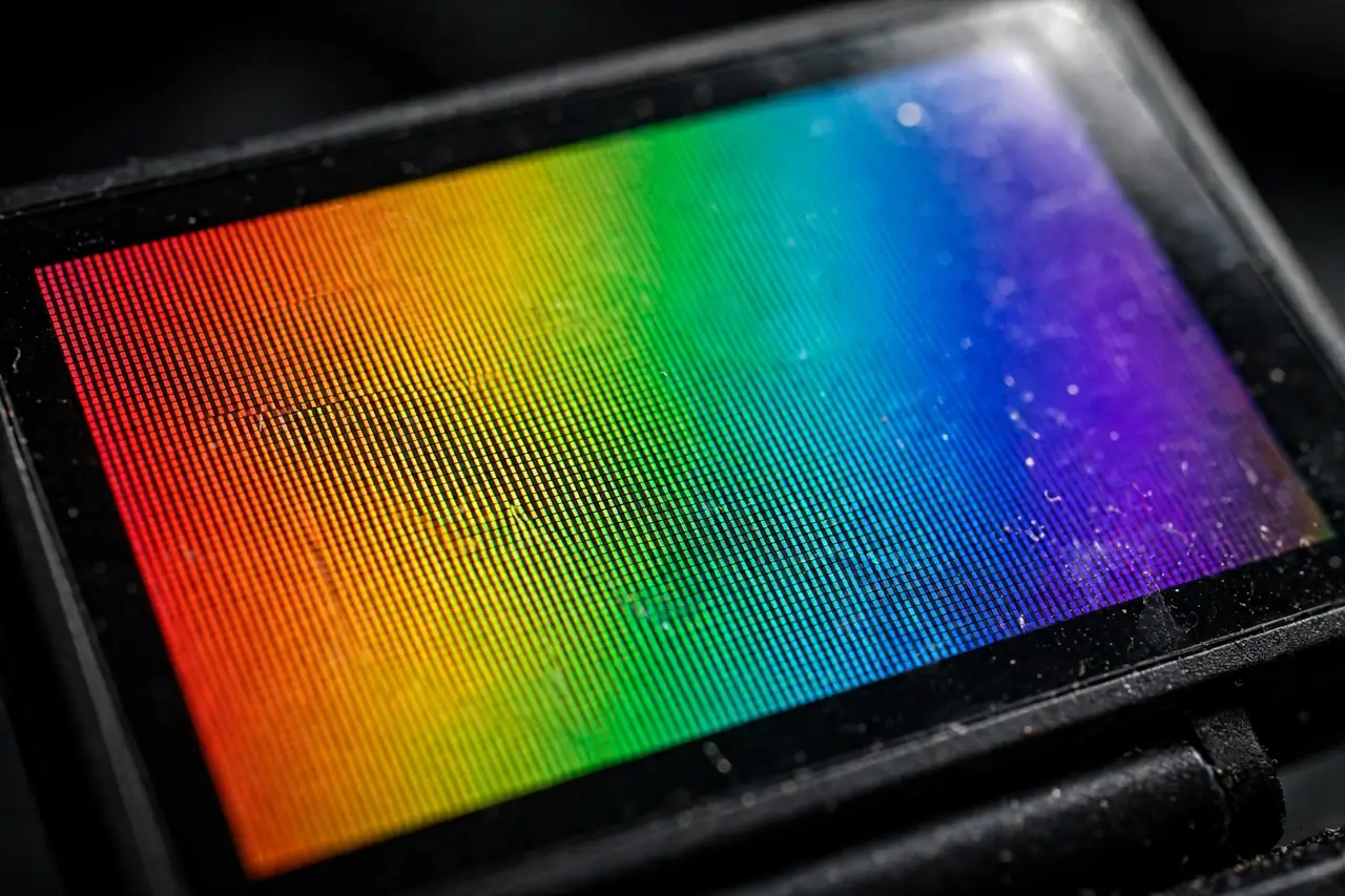 Macro close-up of a portable monitor screen displaying a vivid color-test gradient